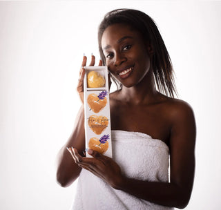 A woman holding up a pack of our Mini Yellow Hearts - Lavender Bath Bombs - Sleep with lavender, ylang ylang and lemon flor y Amor