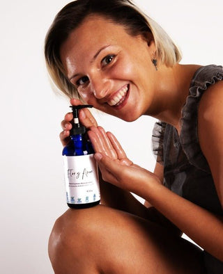 A woman holds up her reinvigorating body oil with lavandin, rosemary and tea tree after use